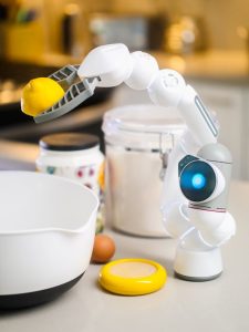 A robot squeezes a lemon into a bowl