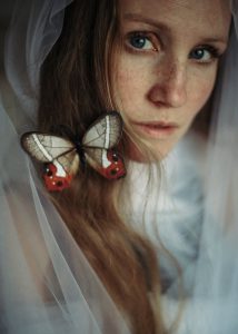 A woman with a butterfly in her hair. Photo by Alisa on Pexels